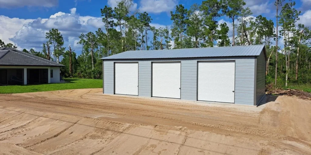 A three car garage with trees in the background.