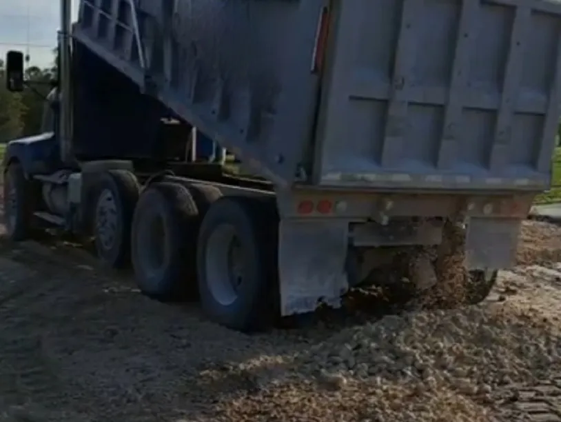 A dump truck is parked on the side of a road.